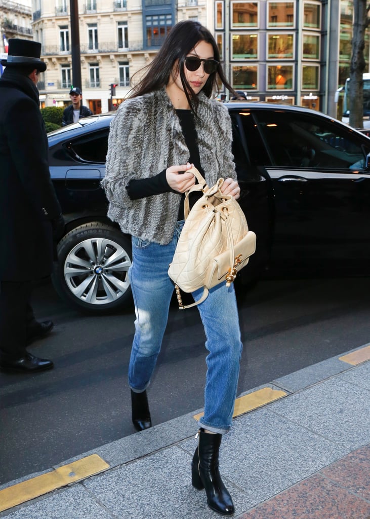 Rolling up her denim to reveal black patent boots and toting her Chanel backpack.
