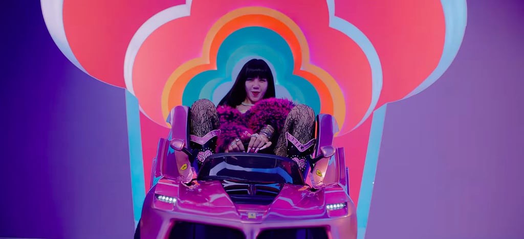 Lisa wears a Miu Miu cat T-shirt underneath her purple furry coat complete with a Bulgari serpent necklace.