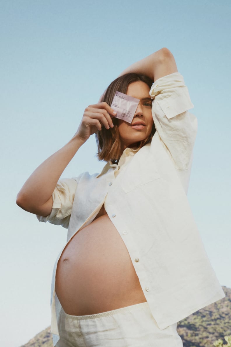 Mandy Moore pregnant wearing an off-white button-up set.