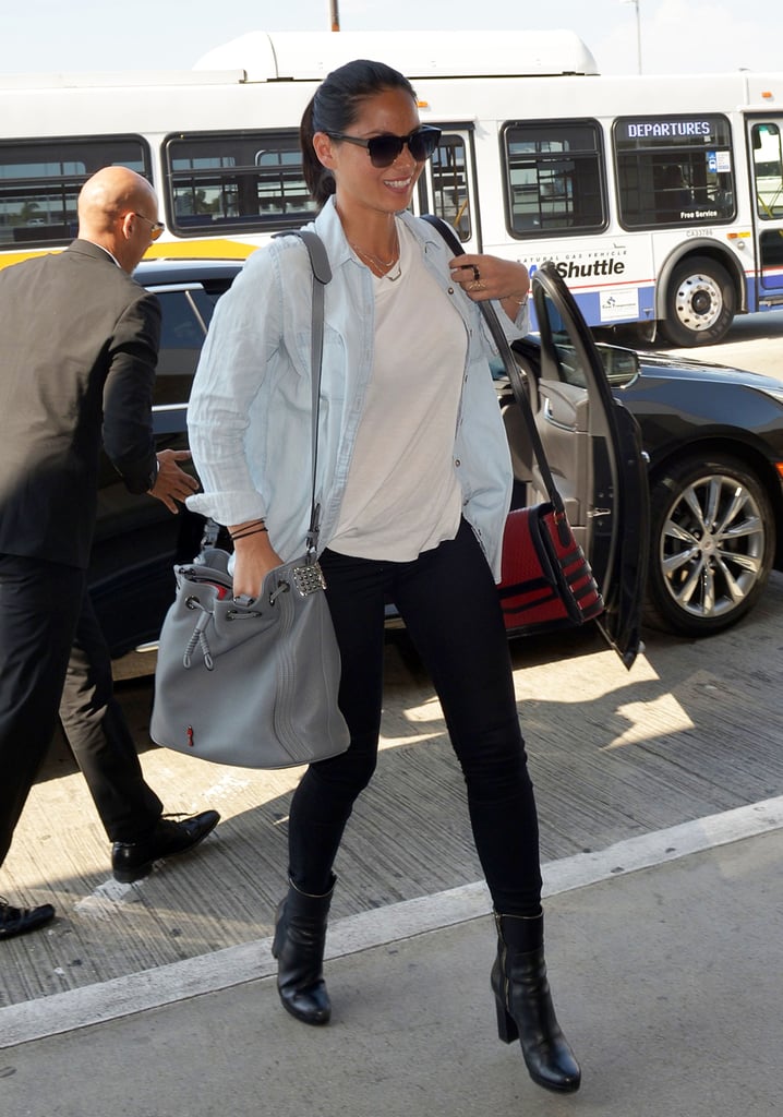 Olivia Munn added interest to her black and white airport ensemble with a chambray shirt and a gray studded shoulder bag.