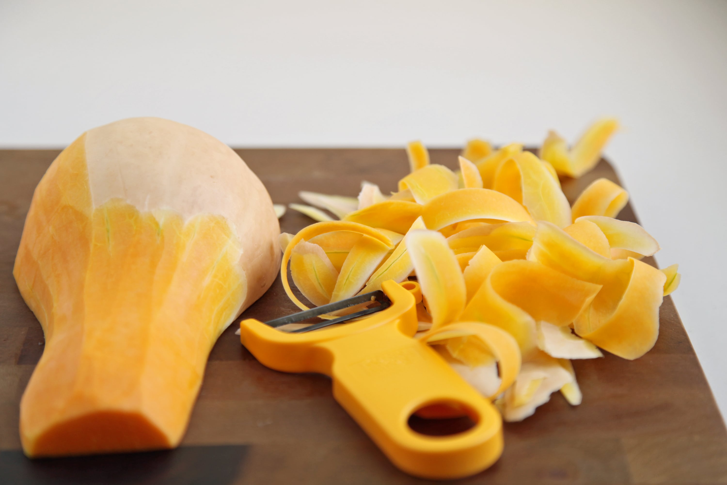 Premium Photo  Peeling fresh green zucchini with peeler. process of  cleaning raw squash with a vegetable peeler.