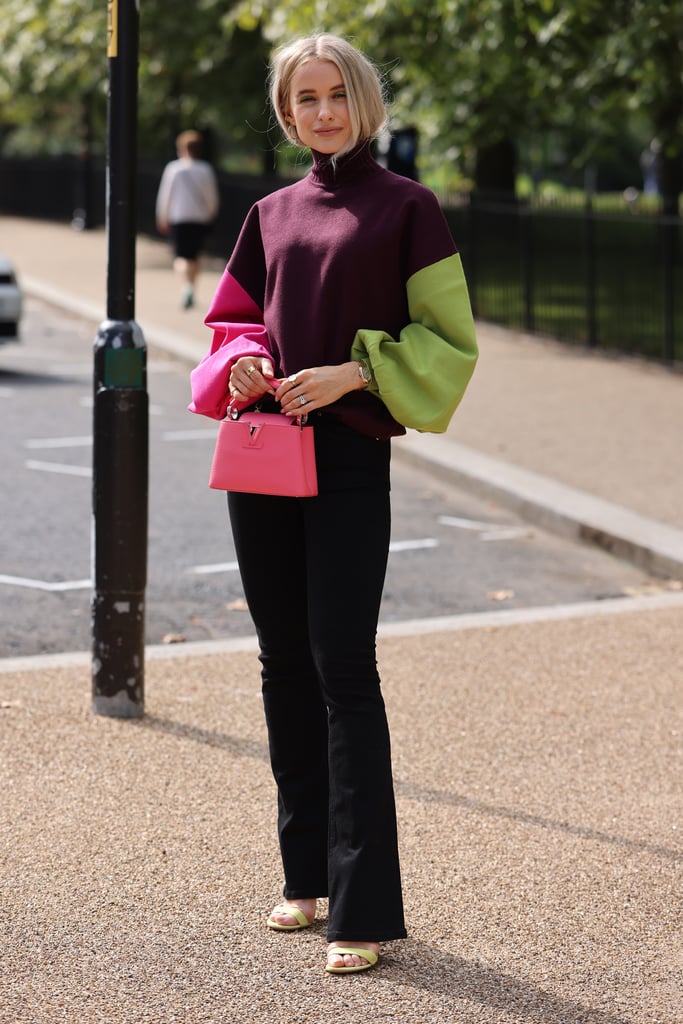 Giving black trousers a little more life is easy with a colorblocked knit and a pop of pink on your bag.