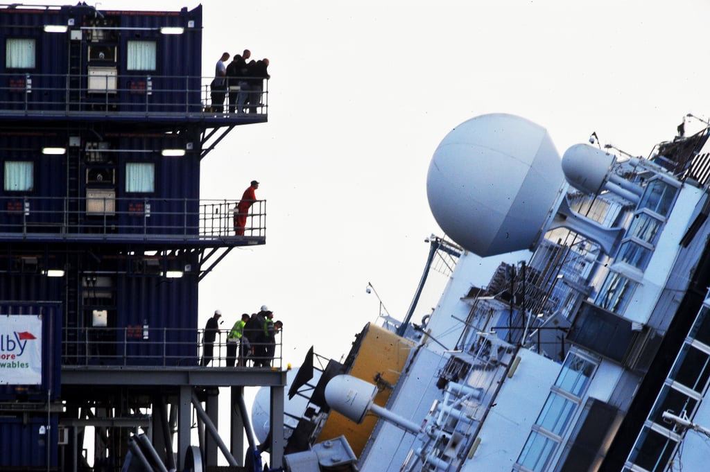 Standing on platforms, the workers looked on as they prepared to right Costa Concordia.