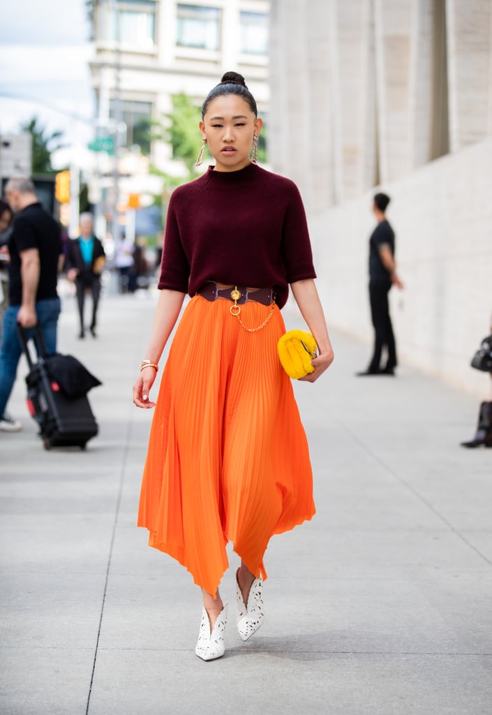 If you're a little wary of bright colour, consider trying out a midi skirt that's styled with a deeper and more neutral tone on top.