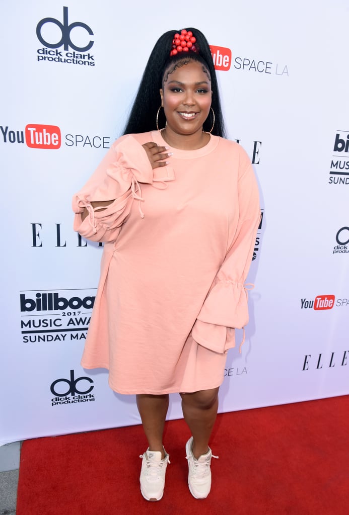 It looks like Lizzo was channeling her inner Ariana Grande in this supercute salmon shirt dress with tiered ruffle sleeves, which she accessorized with a long, high ponytail and white sneakers.