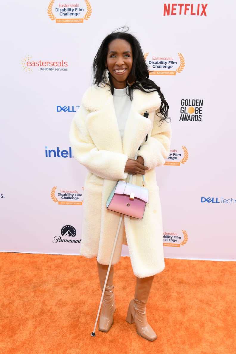 Natalie Trevonne attends the 10th Annual Easterseals Disability Film Challenge at Sony Pictures Studios on May 04, 2023, in Culver City, California. Her full body is pictured as she wears a fur coat, tan shoes, and poses with a purse and cane.