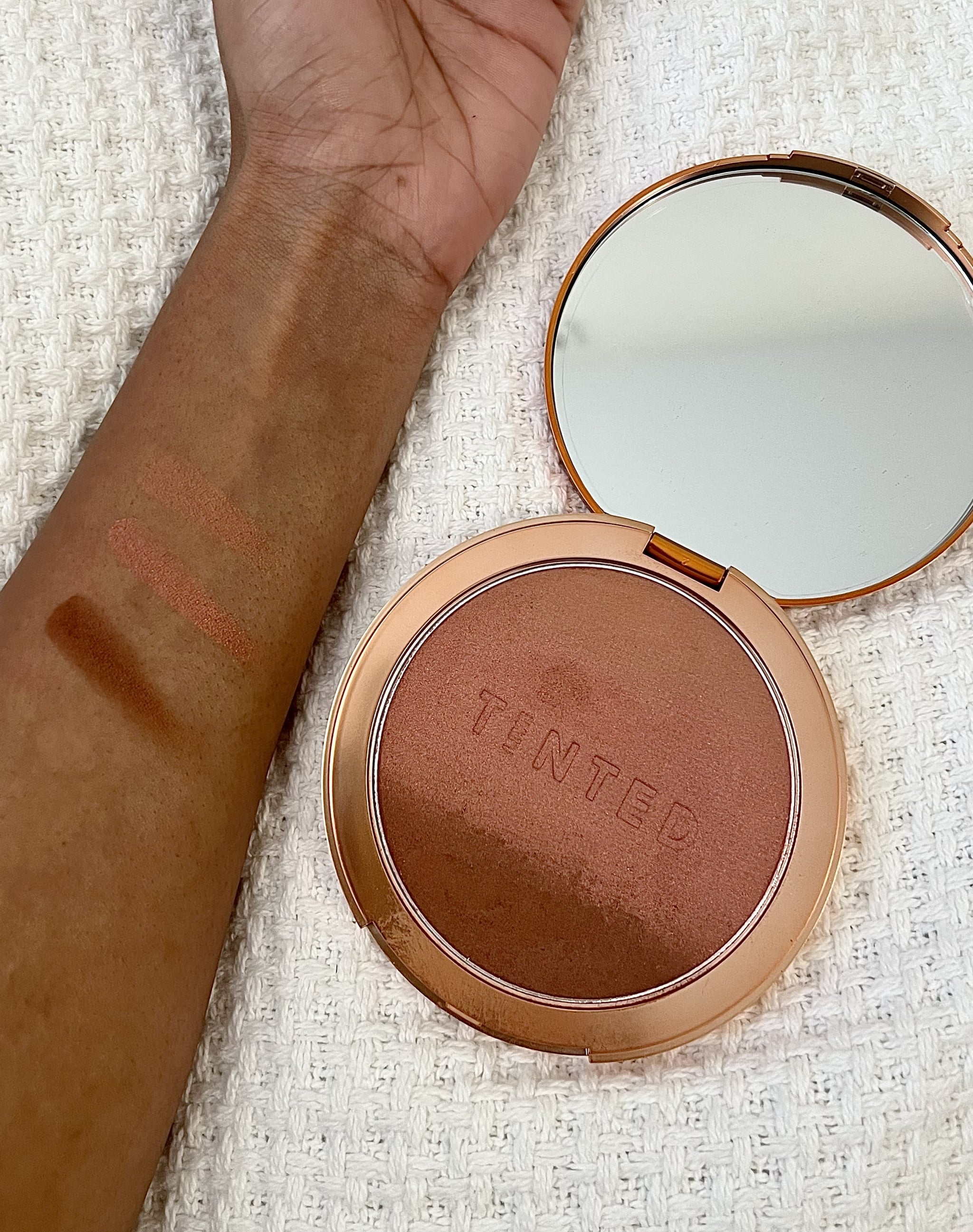  The Live Tinted Huebeam Blushing Bronzer along with swatches of the shades. The top shade is a light brown peachy colour, the middle shade is a shimmery rosy pink, and the bottom shade is a dark warm brown colour.