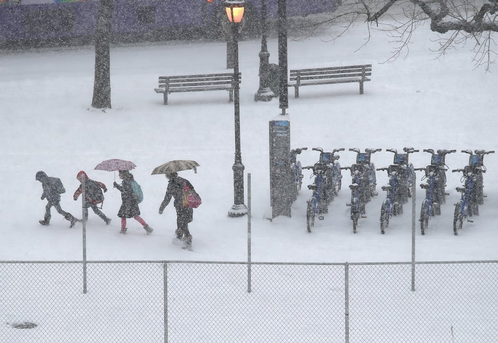 People carried umbrellas to block the wind and snow in NYC.