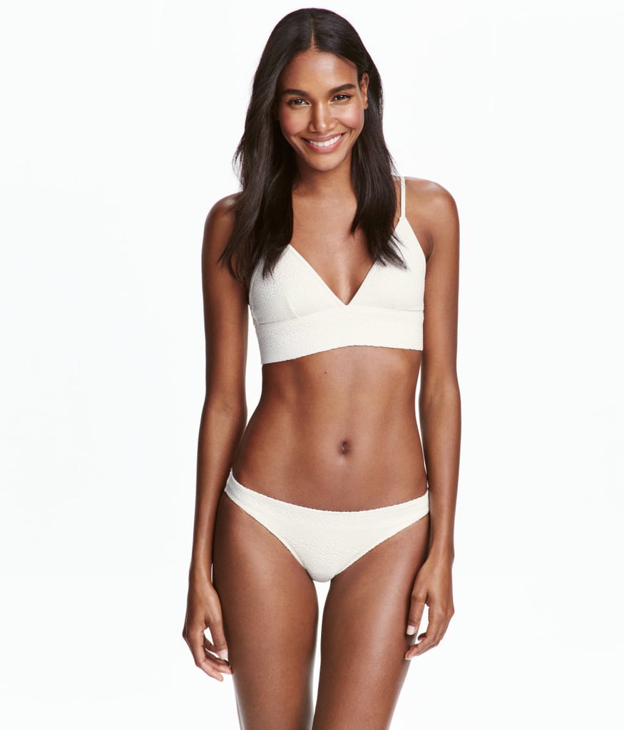 The Suit: H&M Textured Bikini ($13)
Why It Flatters: There's something about the subtle texture and cut of this particular H&M bikini that makes it different from the rest of the styles in your drawer. The slightly extended top makes it not quite a tankini, not quite a bra, but it offers the illusion of a longer torso. Plus, this silhouette has been remade in multiple colors and prints the past few seasons — that's how you know it's a keeper.