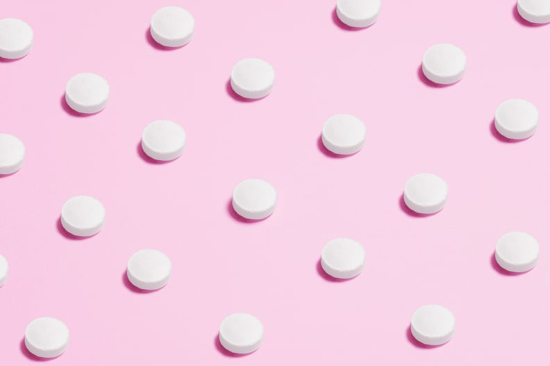 白色B计划药片在粉红色的背景