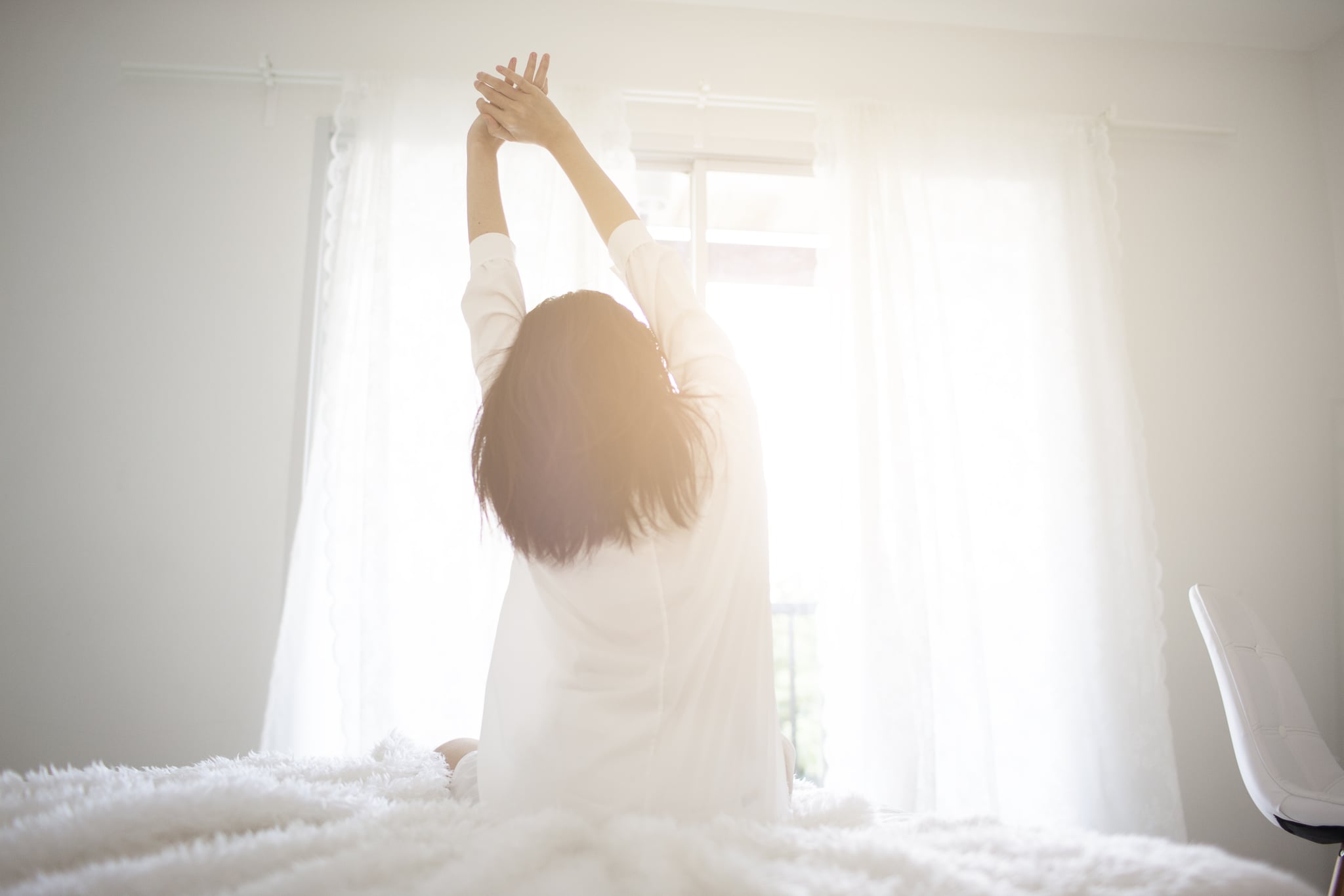 early morning Asian Business girl wake up  on Cosy bed room and soft flare filter Business and technology concept