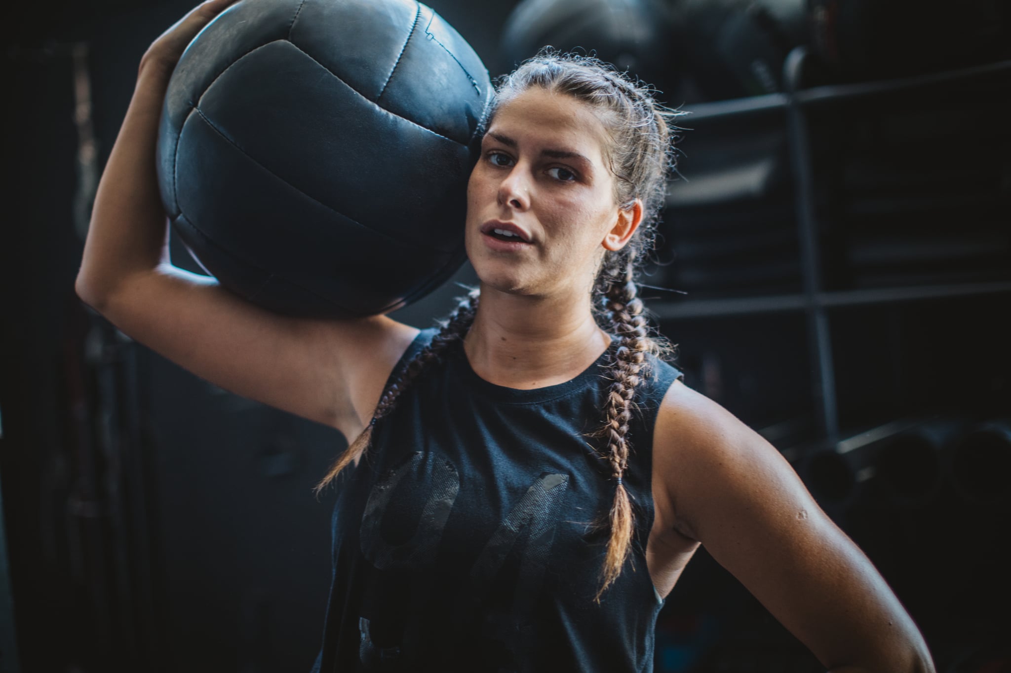 Athlete woman in gym practicing cross training with medicine ball