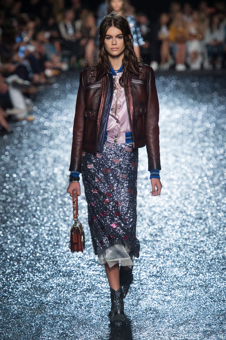 Kaia Walked in the Coach Show in a Leather Jacket and Shimmering Midi Skirt