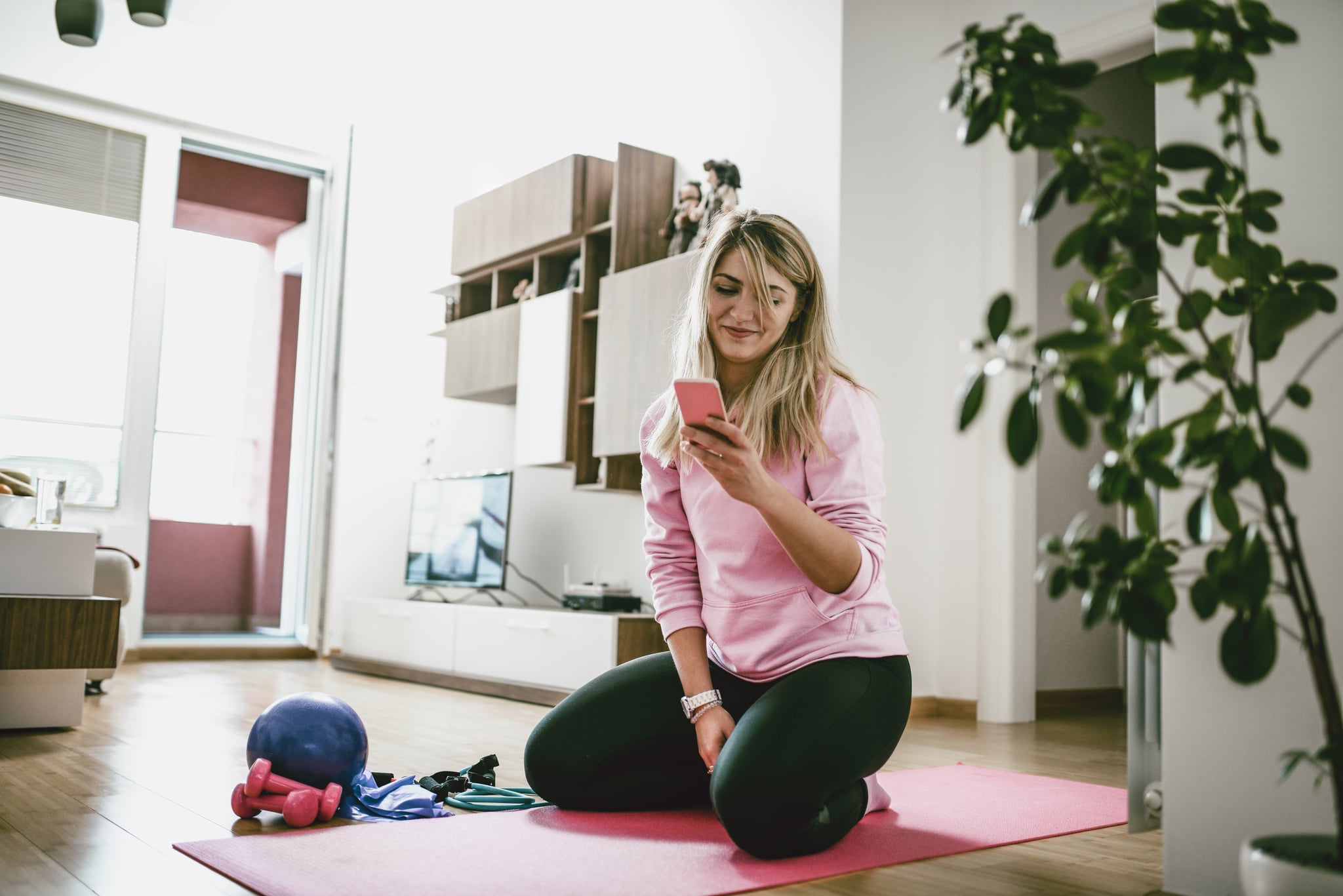 Fit Female Stretching At Home On Exercise Mat And Taking Selfie On Smartphone