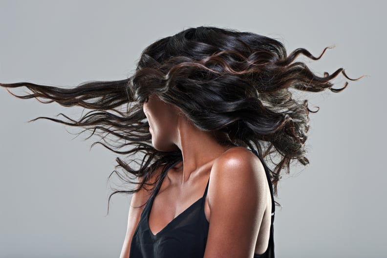 Studio shot of a young woman with beautiful hair isolated on gray