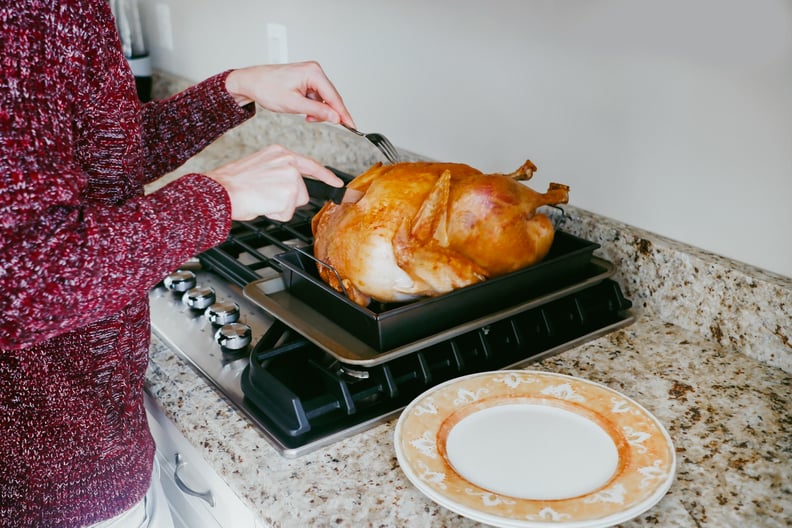 person carving thanksgiving turkey: how long can cooked turkey stay in the fridge?