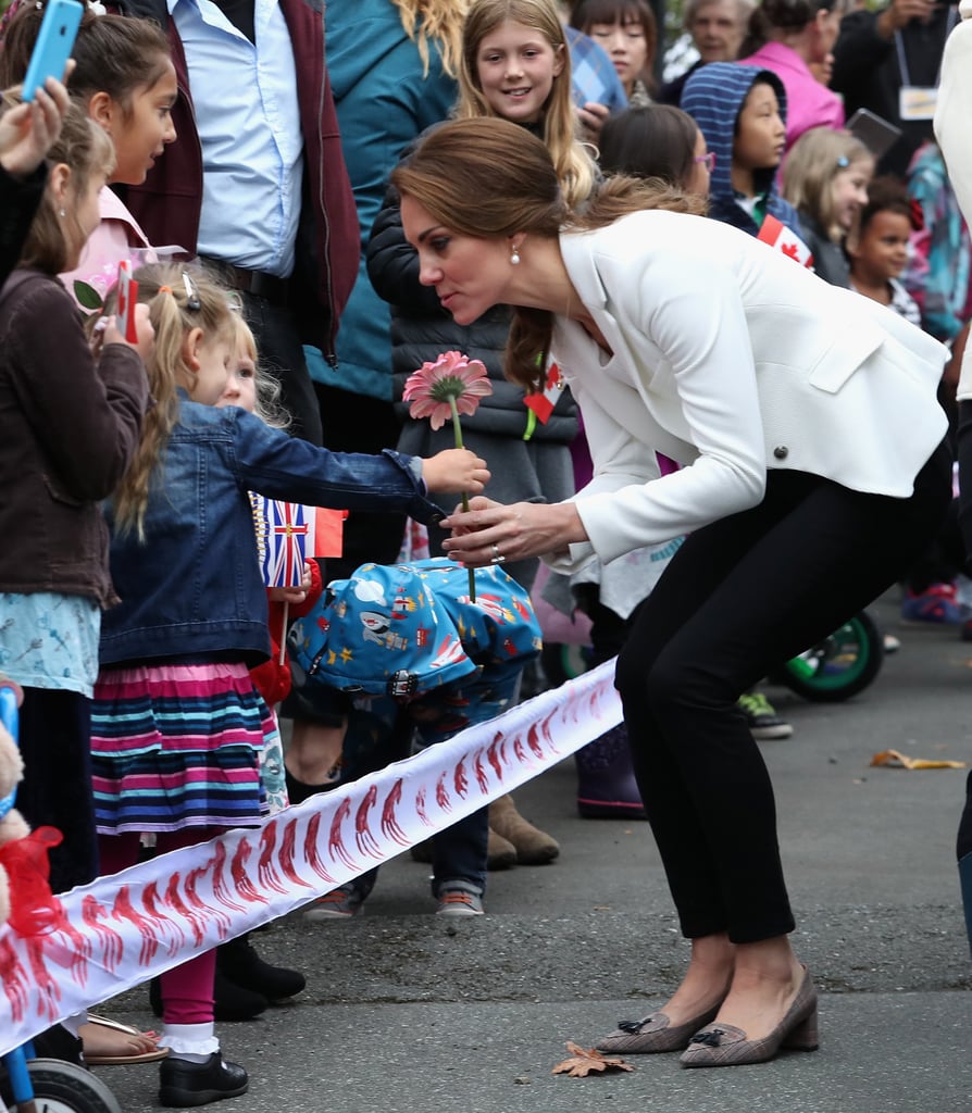 Kate knelt down to accept a daisy from a little girl during their royal tour of Canada in October 2016.