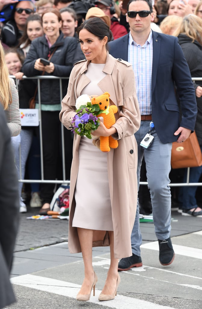 In New Zealand, Meghan covered a lighter-toned Brandon Maxwell dress with a classic Burberry trench.