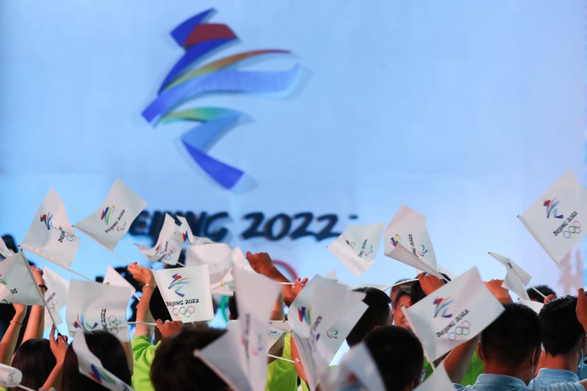 BEIJING, CHINA - SEPTEMBER 17: People wave flags of the Beijing 2022 Winter Olympic Games during the Beijing 2022 Winter Olympic & Paralympic Games Motto Launch Ceremony on September 17, 2021 in Beijing, China. (Photo by Emmanuel Wong/Getty Images)