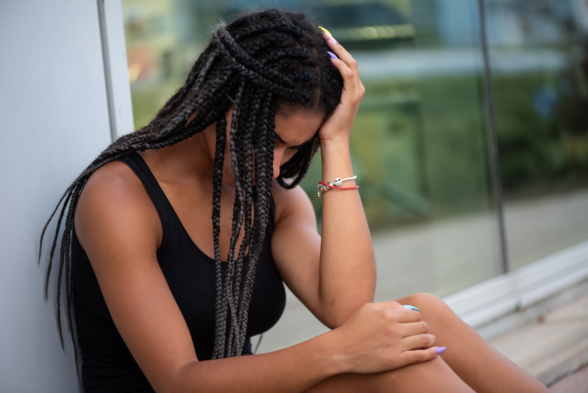 Embarrassed teenager facing down while holding her head