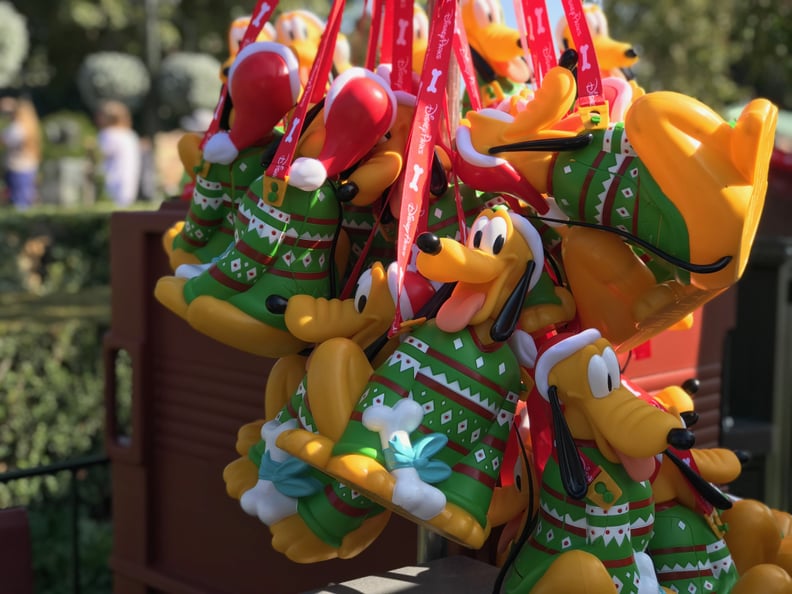 You can find popcorn buckets with Pluto in a Christmas sweater all around Disneyland park.