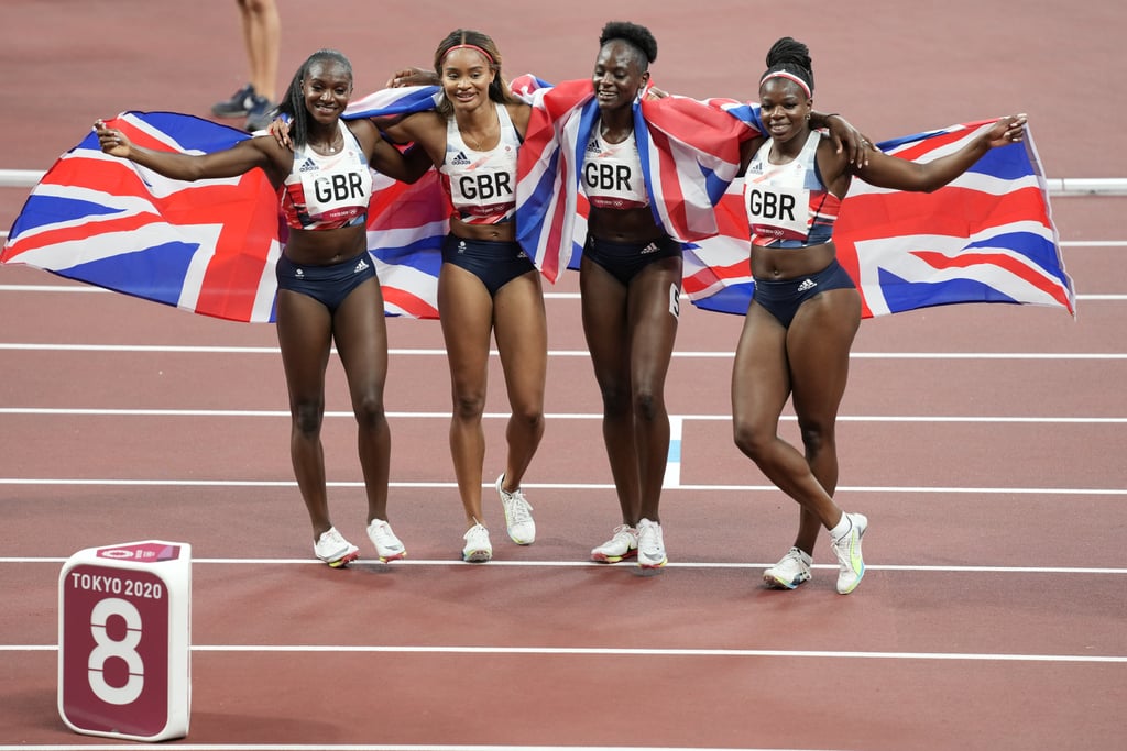 Dina Asher-Smith, Imani Lansiquot, Daryll Nieta, and Asha Philip of Great Britain celebrate winning bronze in the women's 4x100m relay final at the 2021 Olympics.