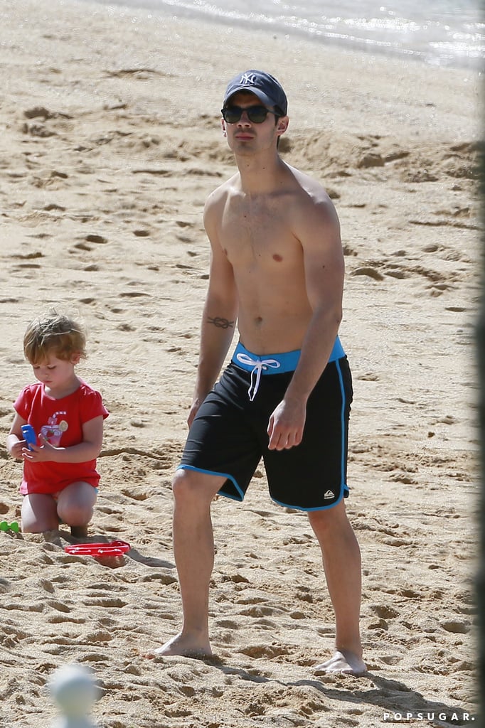 Joe walked shirtless on the beach.