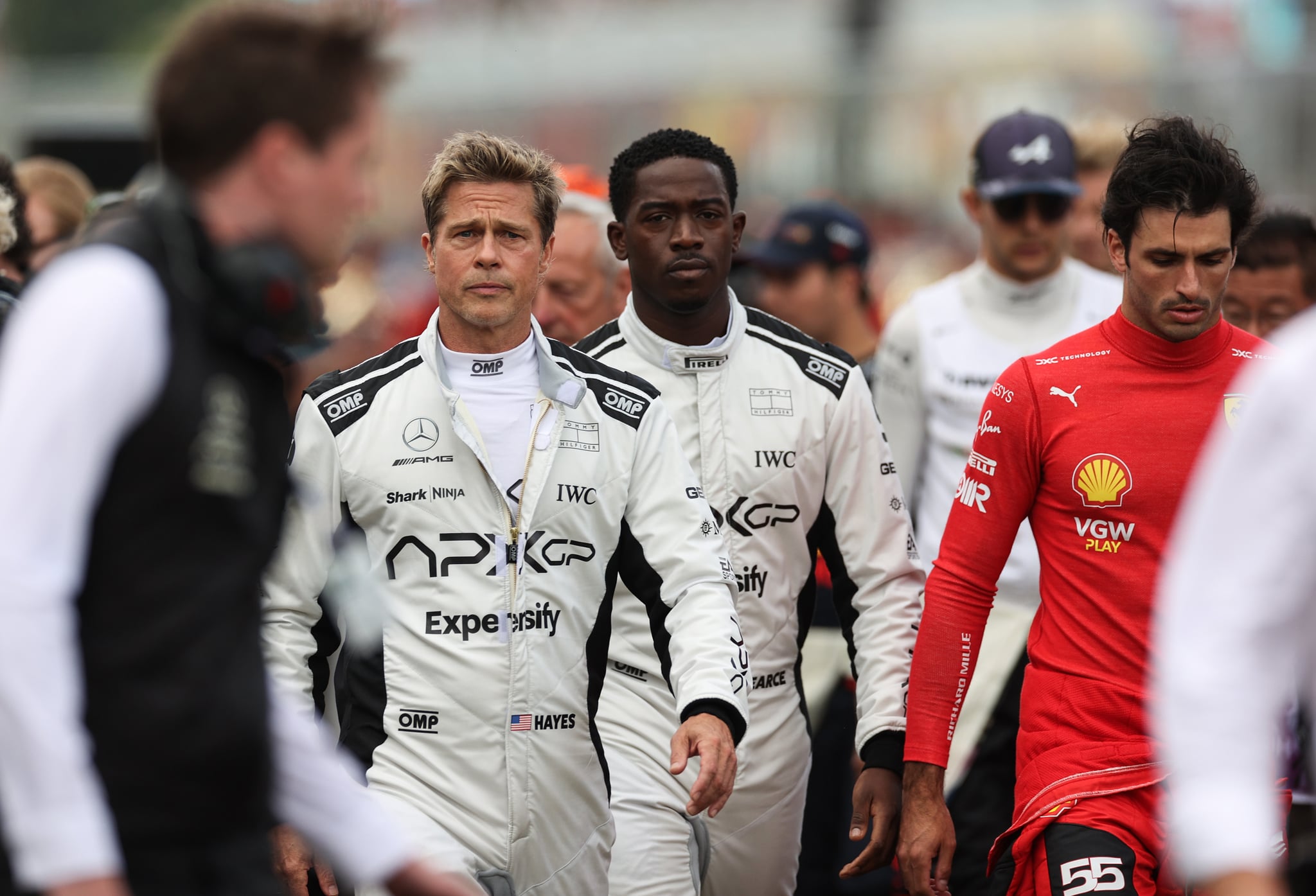 NORTHAMPTON, ENGLAND - JULY 09:  Brad Pitt, star of the upcoming Formula One based movie, Apex, and Damson Idris, co-star of the upcoming Formula One based movie, Apex, walk on the grid in front of Carlos Sainz of Spain driving (55) the Ferrari SF-23 on track during the F1 Grand Prix of Great Britain at Silverstone Circuit on July 09, 2023 in Northampton, England. (Photo by Ryan Pierse/Getty Images)
