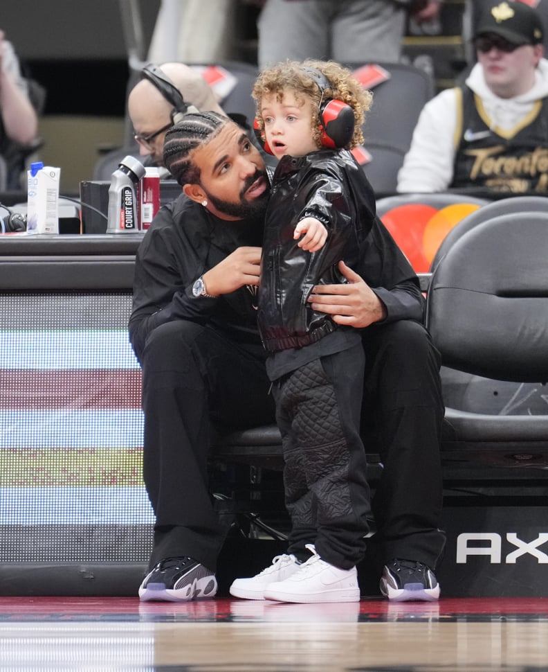 Drake sits with his son Adonis before the Toronto Raptors play the Philadelphia 76ers)