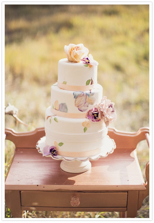 Pastel colors automatically make a cake feel girlie; top that with hand-painted details, and you've got one charming dessert. 
Photo by Alixann Loosle Photography via 100 Layer Cake