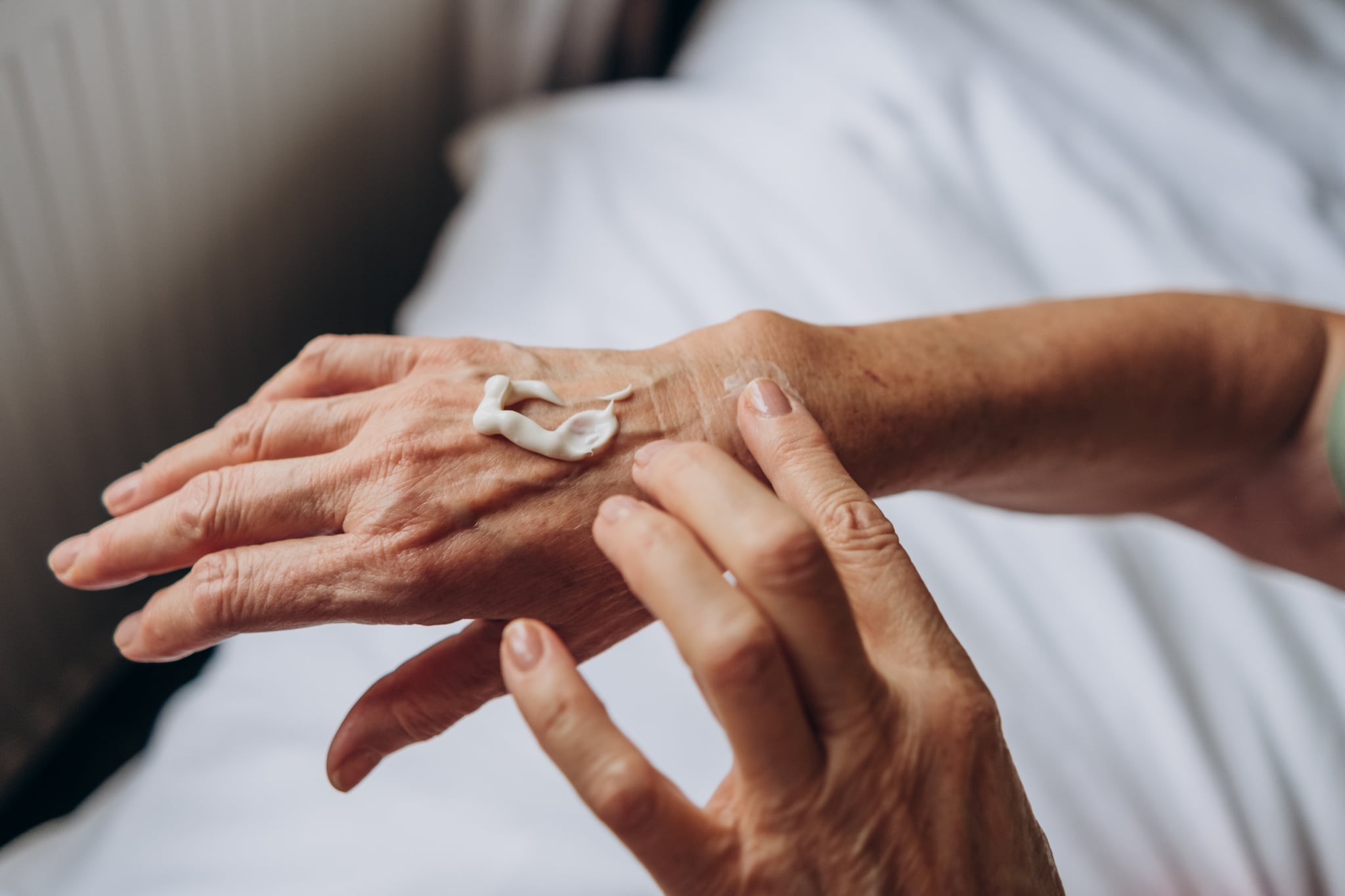 women senior takes care of herselfhand carewoman applying cream to her hands