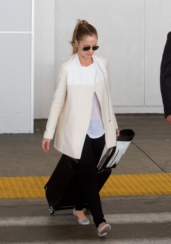 Minka Kelly kept incognito in a sleek white jacket, black skinnies, and aviators. Flats make this look functional, while the white and black palette are one of the chicest ways to hit the jetway.
