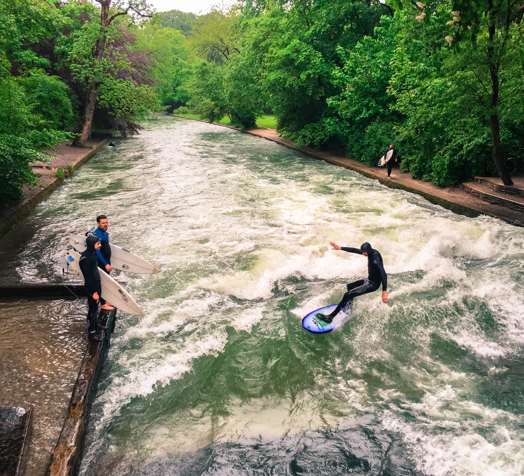 Quick question: would you ever associate Munich with surfing? While this might sound strange given the fact that this German city is landlocked, surfing in Munich is quite the popular activity. River surfing, that is.  
Case in point with the Eisbach surfers. For over 35 years, the churning wall of water that surfaces at the Eisbach bridge has attracted surfers from all over the world. While anyone can try to catch a wave, only experienced surfers are encouraged to get in the water, as the rocks and strong currents make this constricted space rather a dangerous endeavor.
The great part about this surfers' scene is how it's located just a short walk from the English Garden, one of the largest city parks in the world. So after cheering on the experts in the wetsuits, feel free to make your way to the expansive green space that's even larger than New York City's Central Park. With over 900 acres at your fingertips, you'll have plenty of opportunity to relish some fresh air.