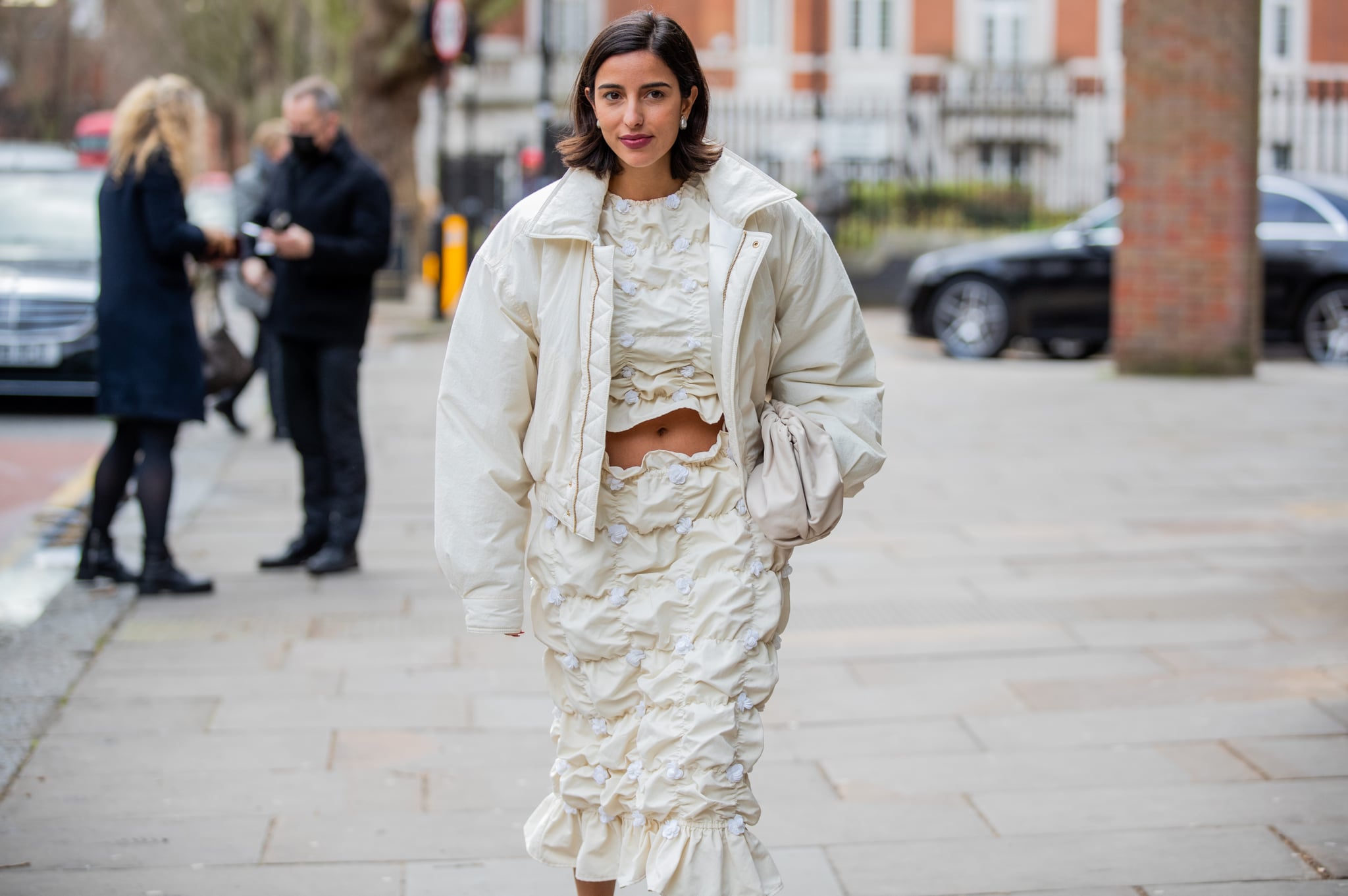 LONDON, ENGLAND - FEBRUARY 21: Bettina Looney seen wearing creme white cropped top, ruffled skirt, Nanushka blouson, heels outside Erdem during London Fashion Week February 2022 on February 21, 2022 in London, England. (Photo by Christian Vierig/Getty Images)