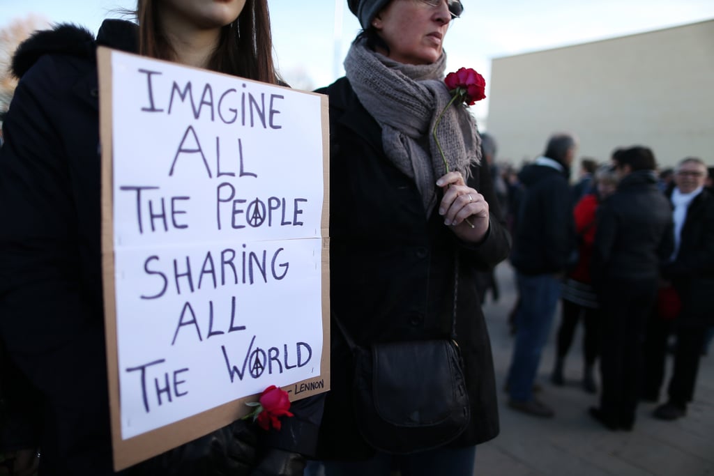 A woman held an inspirational sign with John Lennon lyrics during a gathering in France.