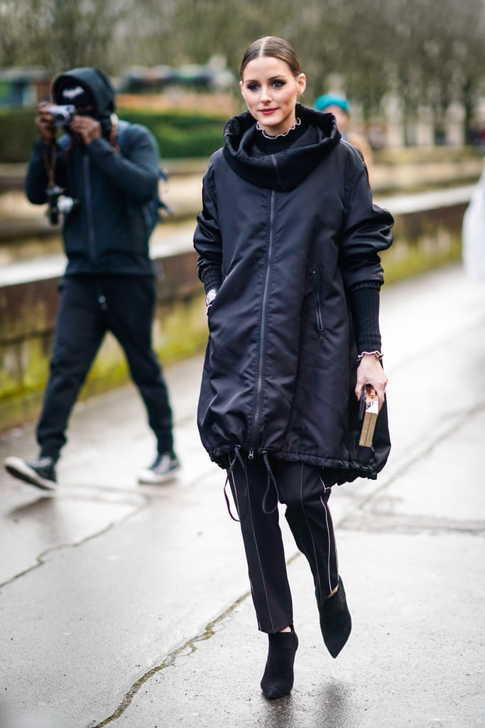She wore a black Valentino "VLTN" long bomber coat with a hoodie outside of the Valentino show.
