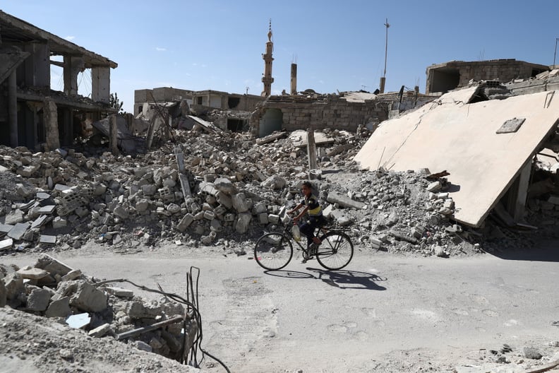 A boy rides his bike amidst the rubble in rebel-held Douma outside of Damascus.