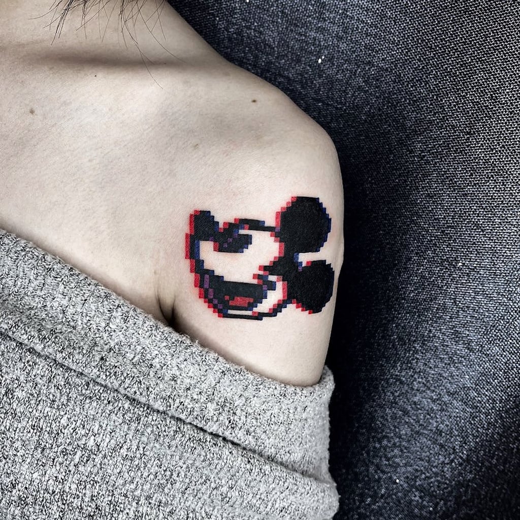 Tiny Mickey Mouse portrait tattoo located on the wrist.