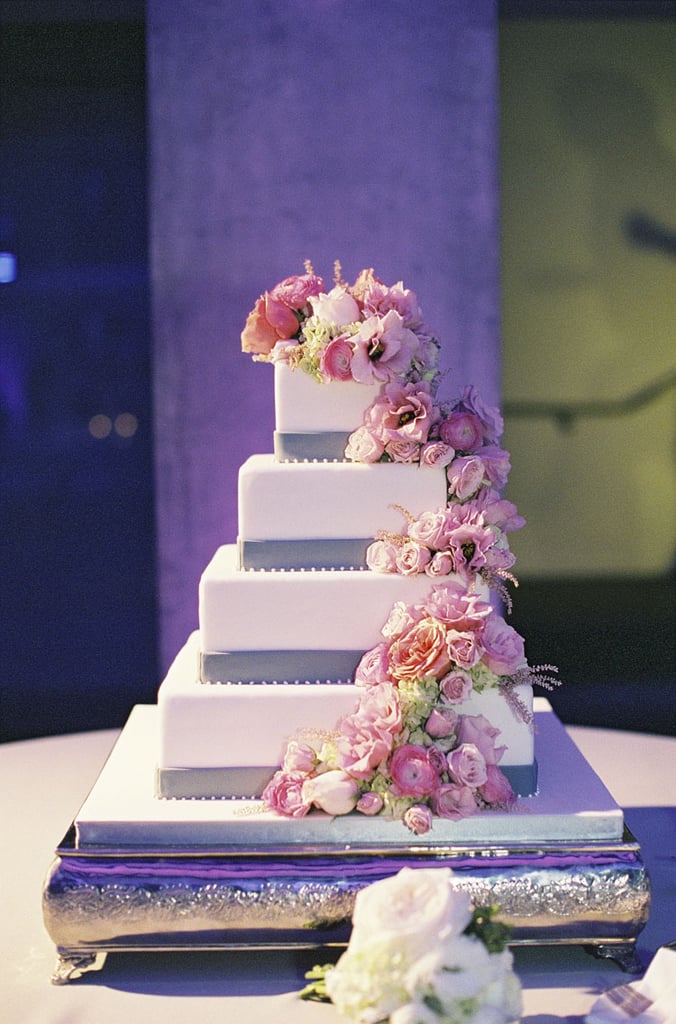 The cascading flowers, purple accents, and four tiers of pretty make this one showstopping cake.