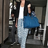 If only our airport looks were half this chic — Miranda capitalized on the pajama-pant trend in a pair of breezy, printed trousers, which she balanced with more polished pieces up top.