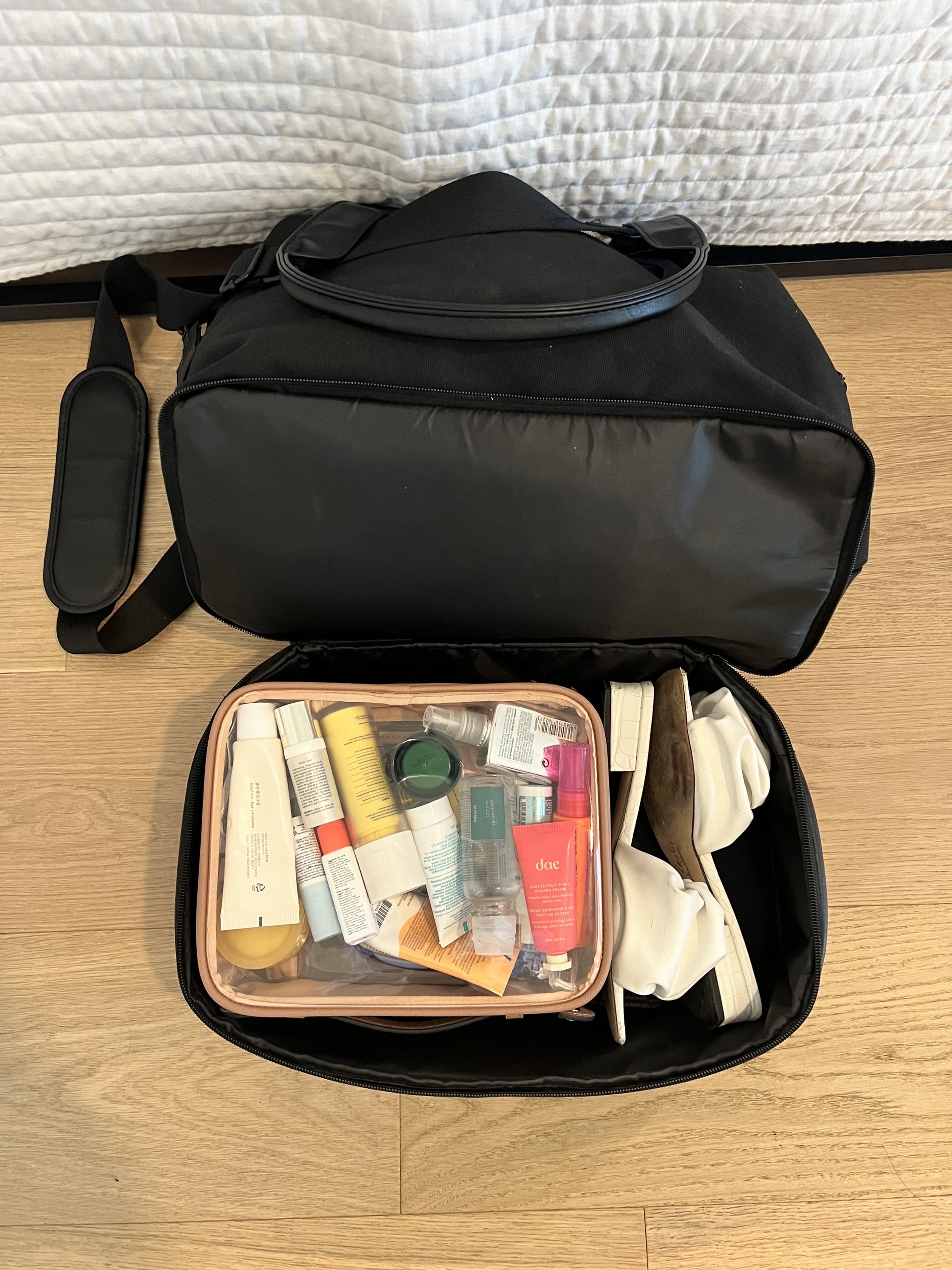 The Calpak Clear Cosmetics Case in the shoe compartment of the Béis Mini Weekender.