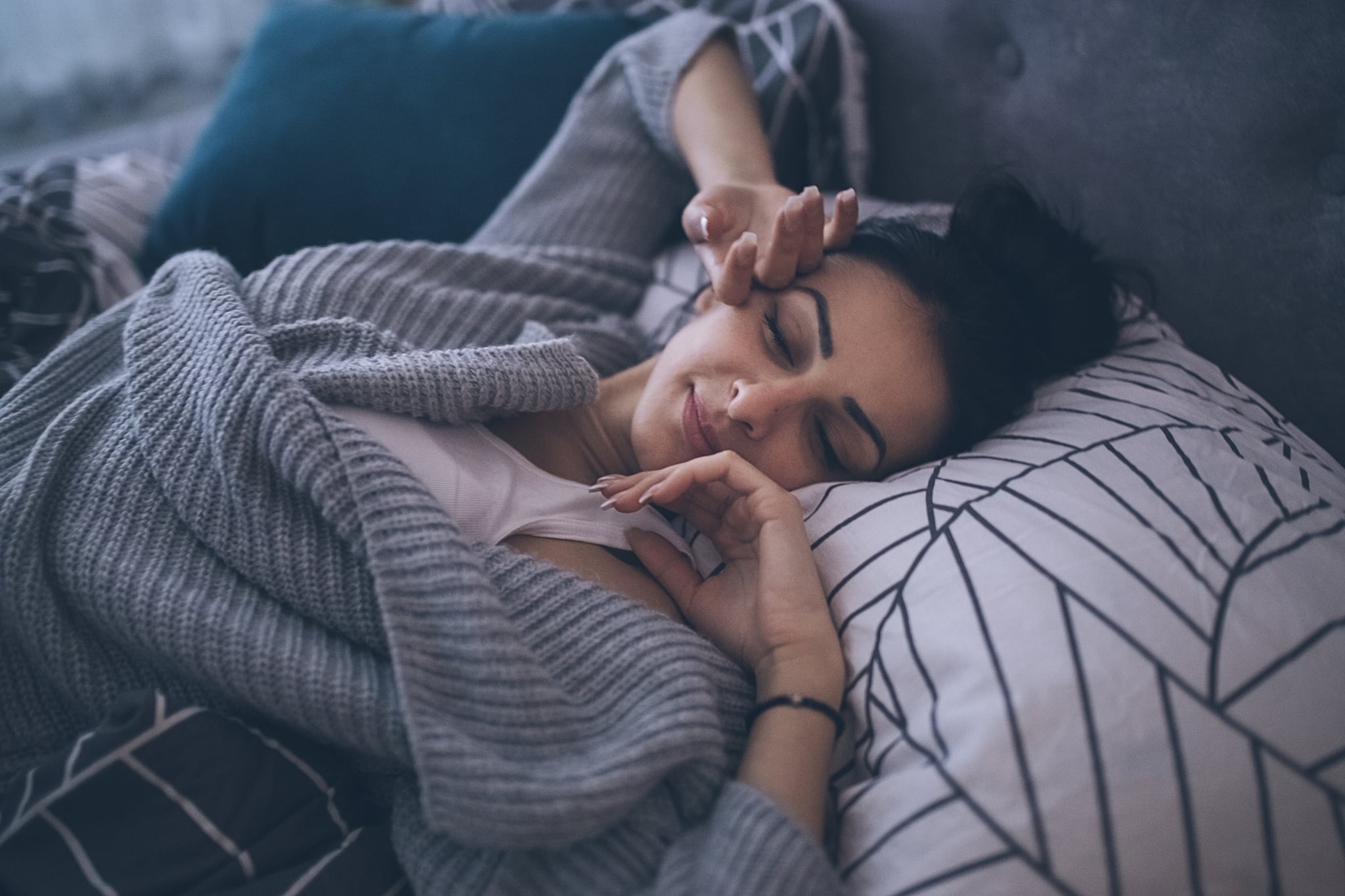 Young woman waking up at her own bed alone, with a smile