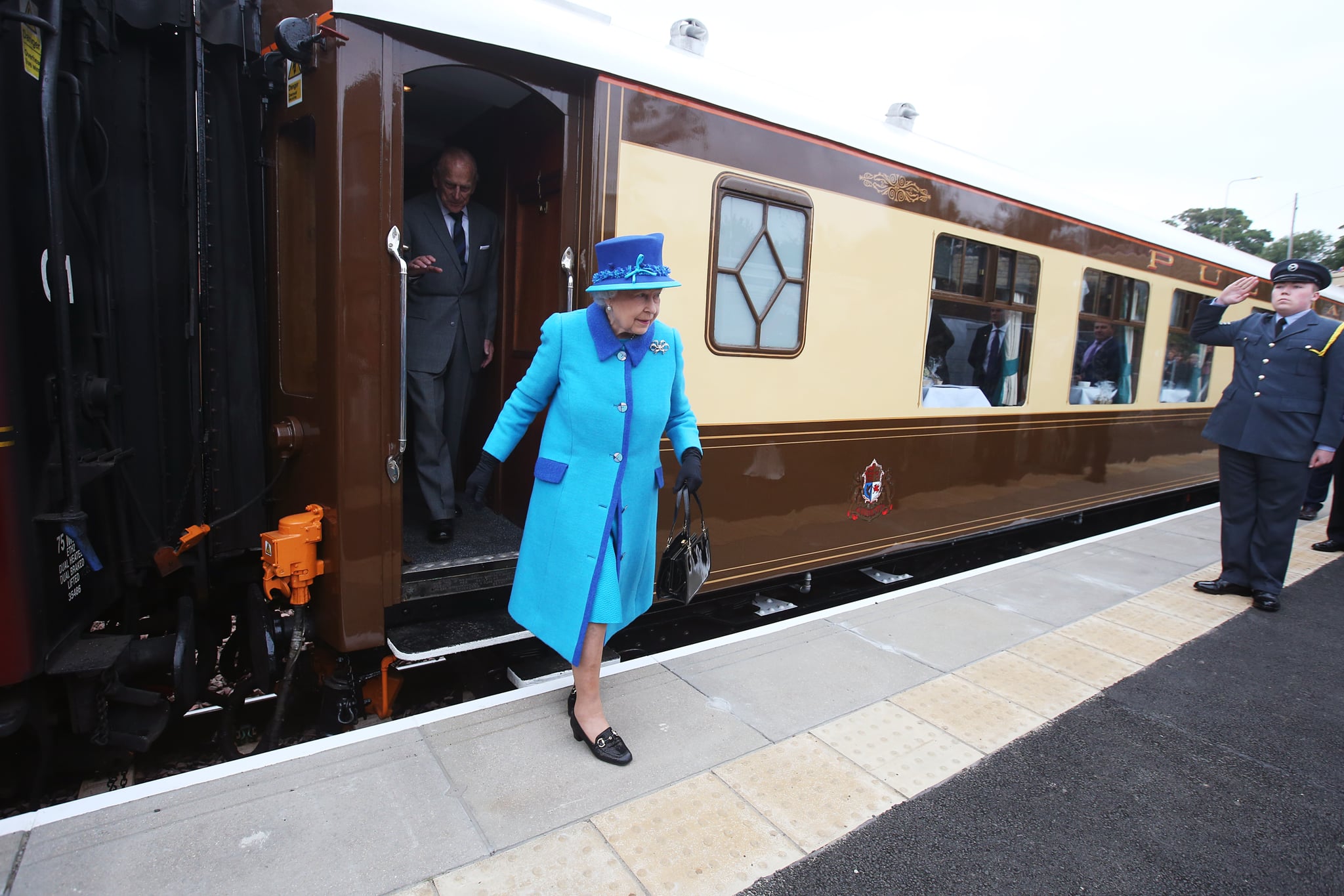 NEWTONGRANGE, SCOTLAND - SEPTEMBER 09:  Queen Elizabeth II arrives to greet well-wishers before she unveils a commemorative plaque at Newtongrange railway station on board the steam locomotive 'Union of South Africa' on the day she becomes Britain's longest reigning monarch on September 09, 2015 in Newtongrange, Scotland. Today, Her Majesty Queen Elizabeth II becomes the longest reigning monarch in British history overtaking her great-great grandmother Queen Victoria's record by one day. The Queen has reigned for a total of 63 years and 217 days. Accompanied by her husband and Scotland's First Minister Nicola Sturgeon she will officially open the new Scottish Border's Railway which runs from the capital to Tweedbank.  (Photo by Andrew Milligan - WPA Pool/Getty Images)