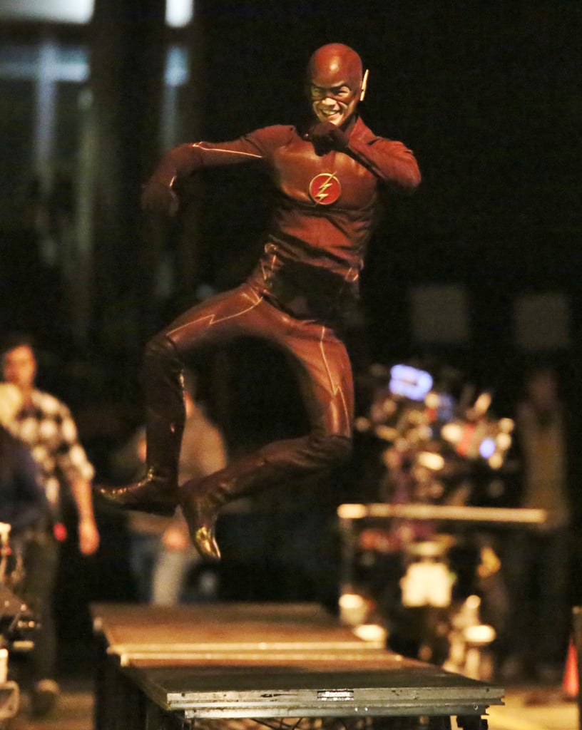 Grant Gustin clicks his heels in his Flash costume.