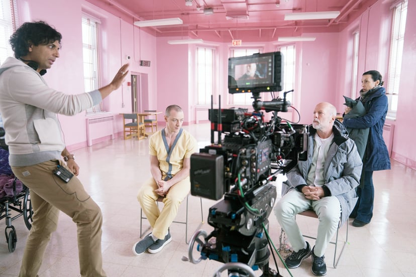 GLASS, from left: director M. Night Shyamalan, James McAvoy, Bruce Willis, on set, 2019. ph: Jessica Kourkounis /  Universal /Courtesy Everett Collection