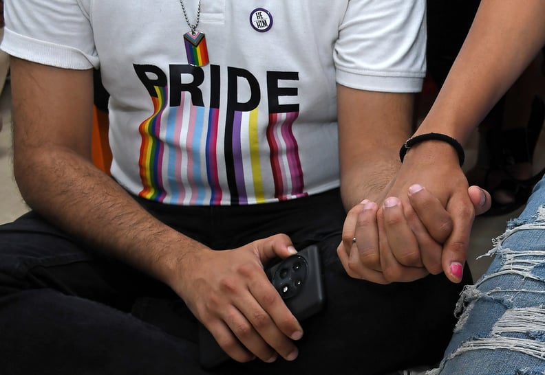 MUMBAI, MAHARASHTRA, INDIA - 2023/10/17: LGBTQ community members hold hands as they watch supreme court judgement of the same sex marriage on a projector screen at Humsafar Trust. A five judge constitution bench refused legal recognition of same sex marri