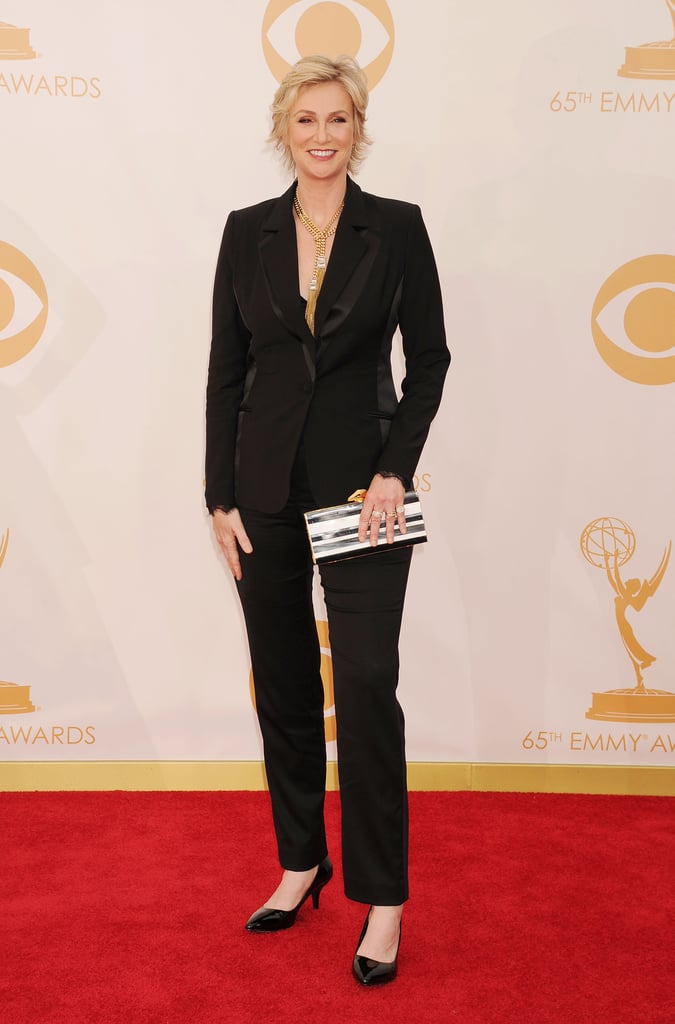 Jane Lynch completed a sharp suit with a pair of black kitten heels, bold gold jewels, and a striped clutch.