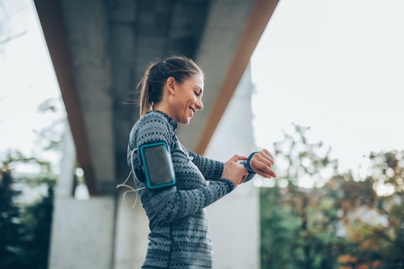 Sportswoman using a smart watch outdoors.