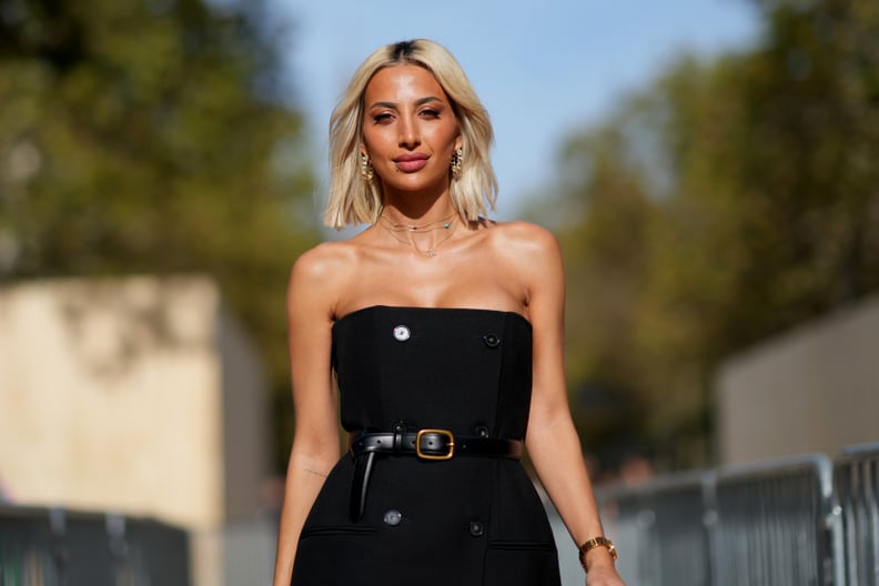 PARIS, FRANCE - OCTOBER 02: Model Roz wears an off-shoulder on-knee black dress, a leather belt, a mauve leather bag, outside Stella McCartney, during the Womenswear Spring/Summer 2024 as part of  Paris Fashion Week on October 02, 2023 in Paris, France. (