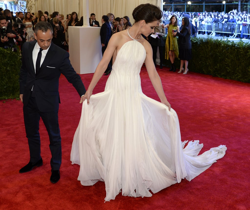 Katie Holmes enlisted a little help to get her train just right on her Calvin Klein Collection gown at the 2013 Met Gala.
